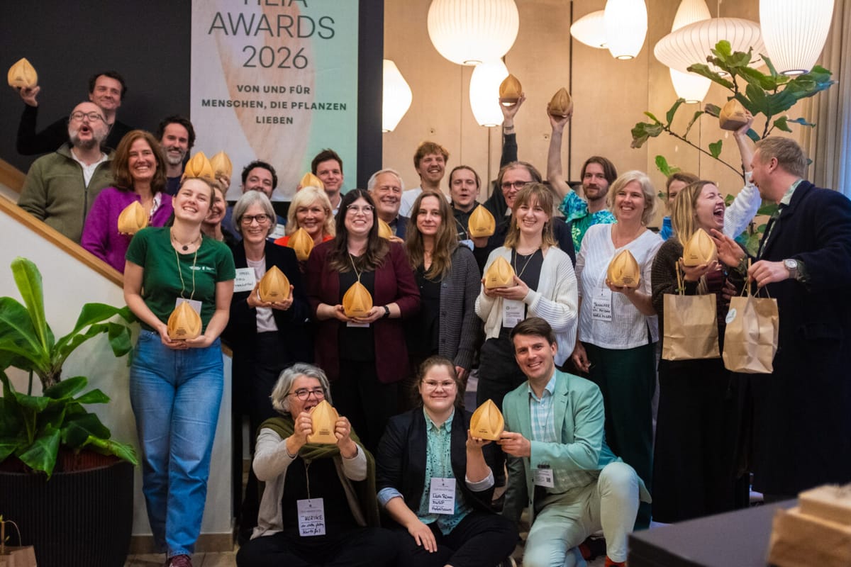 Gruppenszene mit Gewinnerinnen der Tilia Awards 2026, die ihre Auszeichnungen in die Höhe halten, umgeben von Pflanzen.