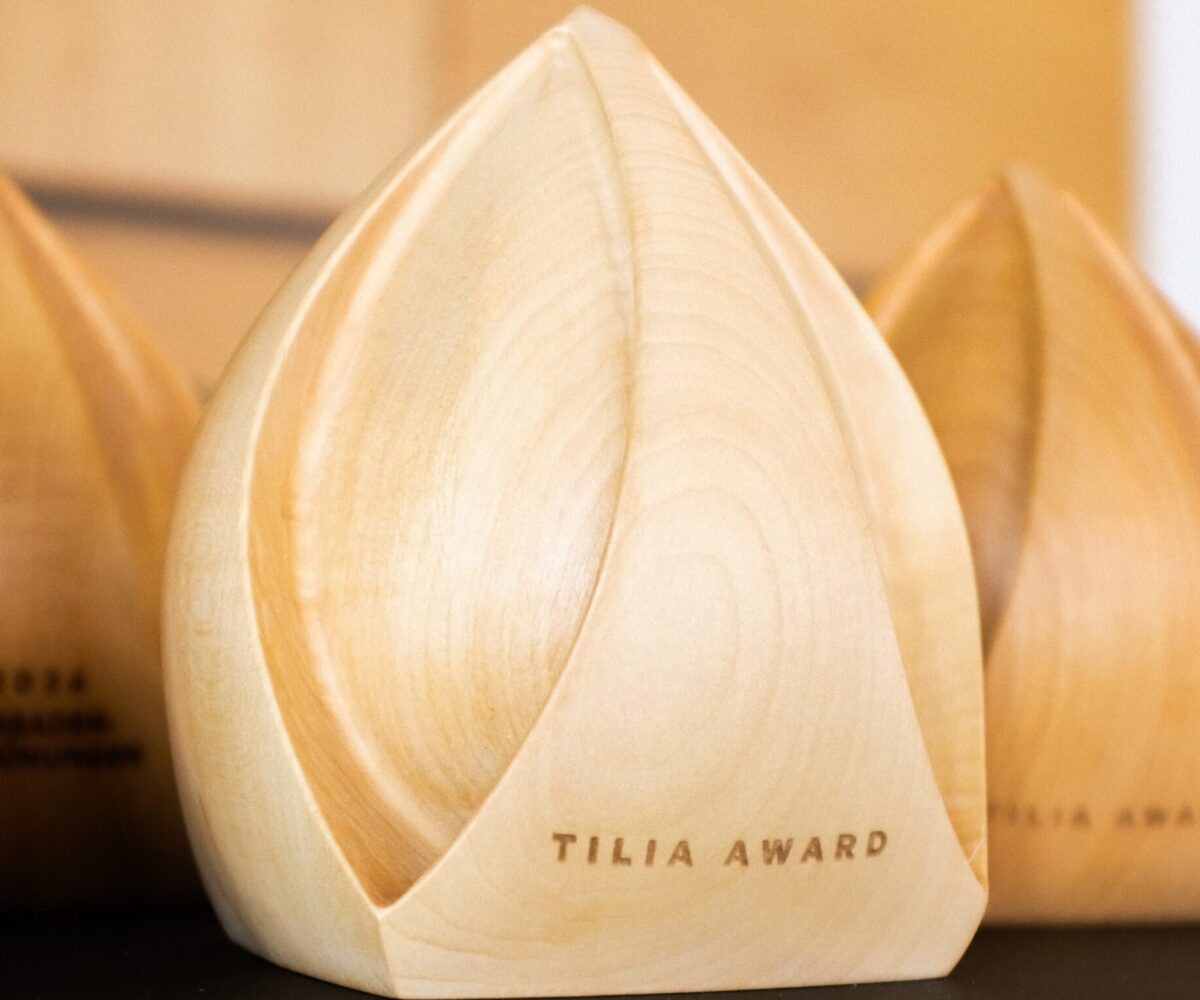 Mehrere hölzerne Tilia-Award-Skulpturen in Form einer Knospe, aufgereiht auf einem Tisch.